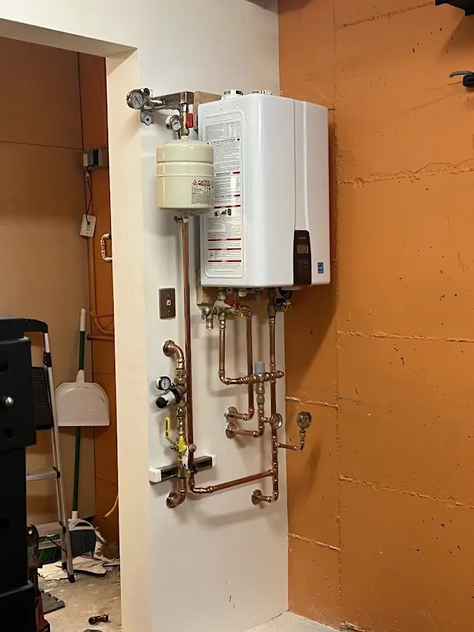 Plumbing technician inspecting water heater connections in Oakland